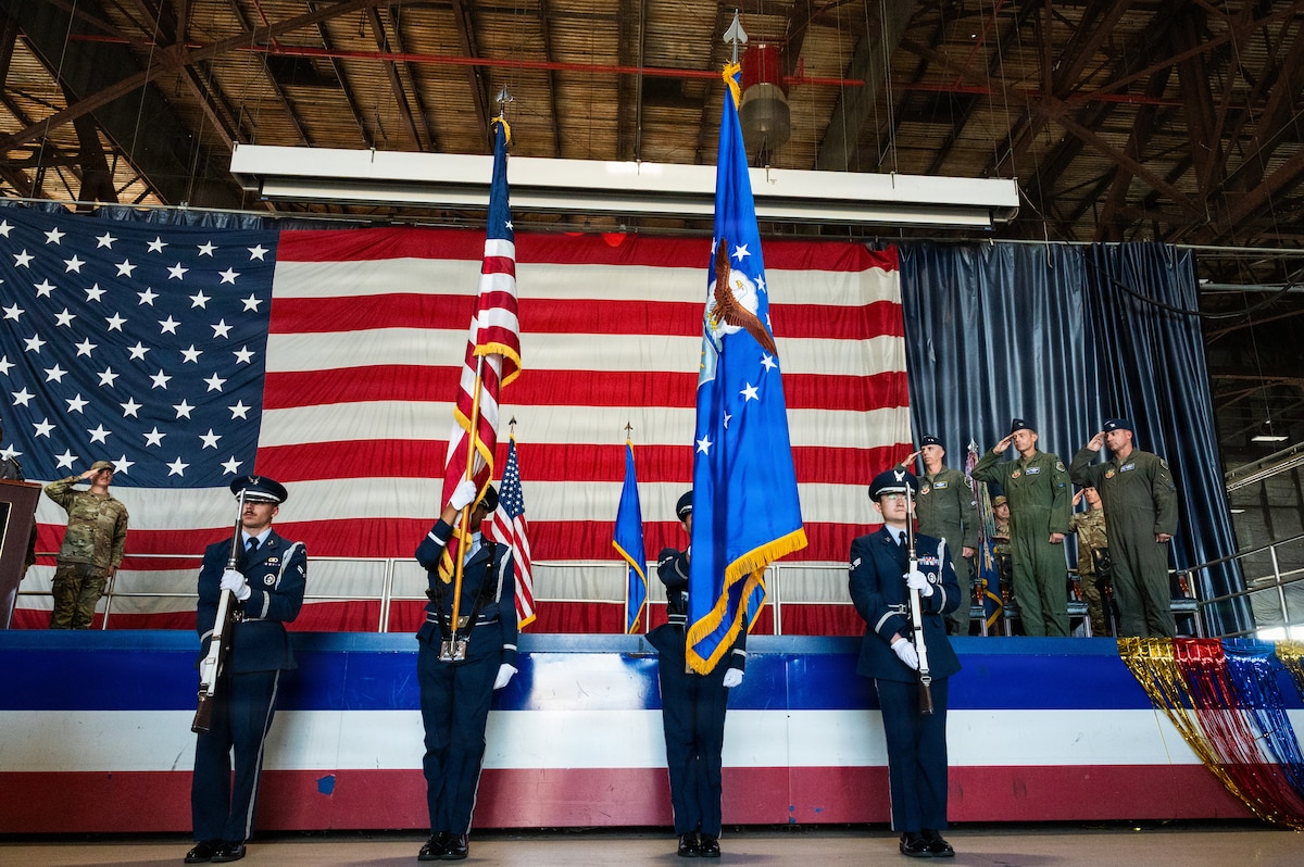 Honor guardsman present colors.