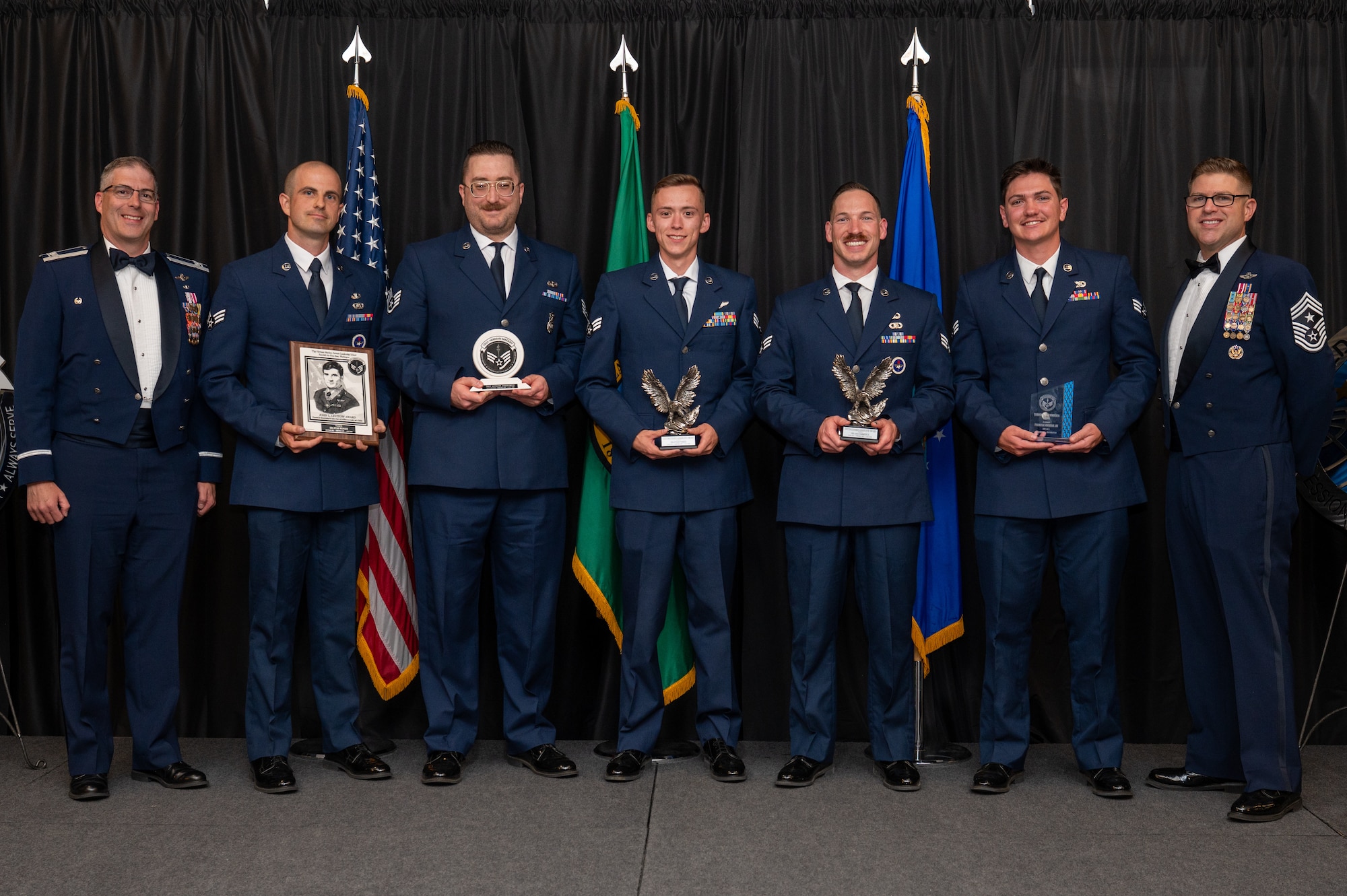 Award winners of the Herman Mackey Airman Leadership School class 26-E pose for a group photo with Col. Nathan McClure, 336th Training Group commander, left, and Chief Master Sgt. Bob Wyman, 92nd Air Refueling Wing command chief, during the ALS graduation ceremony.