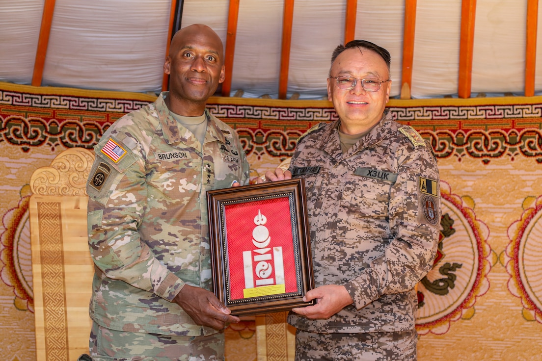 U.S. Army Gen. Xavier T. Brunson and Mongolian Maj. Gen. Chimedgochoo Tsogtjargal stand together in military uniforms as the Mongolian commander presents a gift to Gen. Brunson at the Five Hills Training Area near Ulaanbaatar, Mongolia, during exercise Khaan Quest 2026.