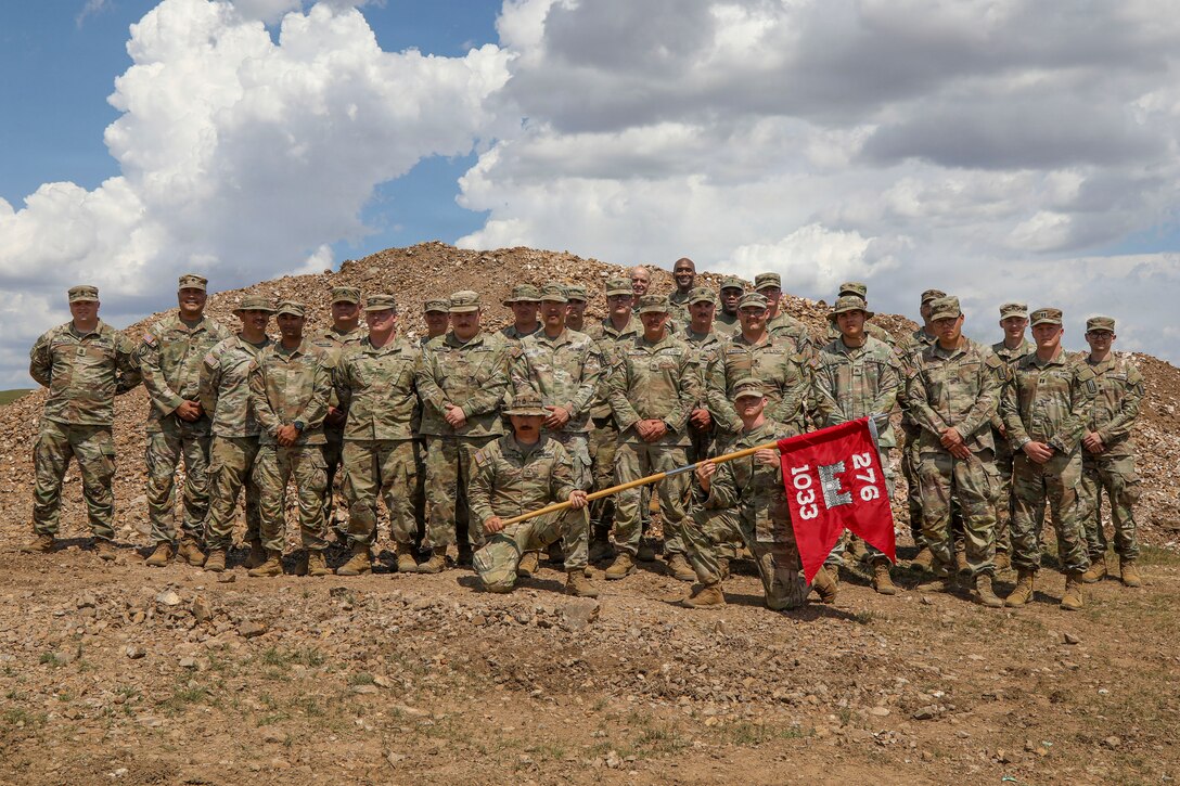 A large group photo of U.S. Army Gen. Xavier T. Brunson and Command Sgt. Maj. Robin M. Bolmer standing with Soldiers of the 1033rd Engineer Support Company, 276th Engineer Battalion, Virginia Army National Guard. The group is posed outdoors in utility uniforms at the Five Hills Training Area near Ulaanbaatar, Mongolia, during exercise Khaan Quest 2026.