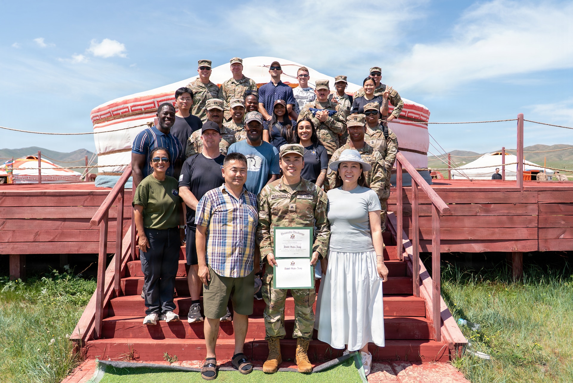 U.S. Army Sgt. Munk Munkhzaya, center, poses for a photo with his parents and fellow Soldiers following his reenlistment ceremony inside a traditional Mongolian ger at Five Hills Training Area, Mongolia, July 2, 2026.