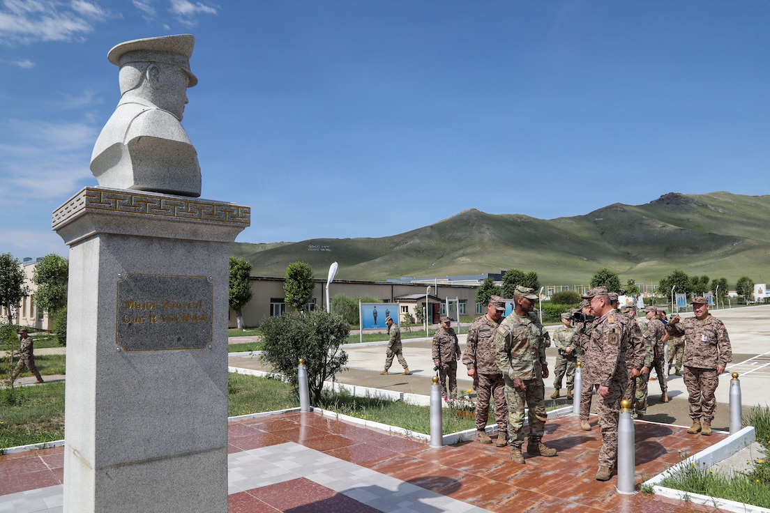 U.S. Army Gen. Xavier T. Brunson, alongside U.S. Army and Mongolian Armed Forces senior leaders, stands in front of the statue of Mongolian Maj. Gen. Güriin Ragchaa outdoors at the Five Hills Training Area in Mongolia.