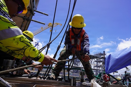 Joshua Kaahanui and Blake Tadaki, shipwrights with Pearl Harbor Naval Shipyard and Intermediate Maintenance Facility (PHNSY & IMF), rig a container off USS Illinois (SSN 786) at Joint Base Pearl Harbor-Hickam, June 24, 2026.