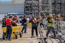 Sailors and shipyard employees work together to heave in line during the undocking of Virginia-class fast-attack submarine USS Illinois (SSN 786) from Dry Dock 2 at Pearl Harbor Naval Shipyard and Intermediate Maintenance Facility (PHNSY & IMF).