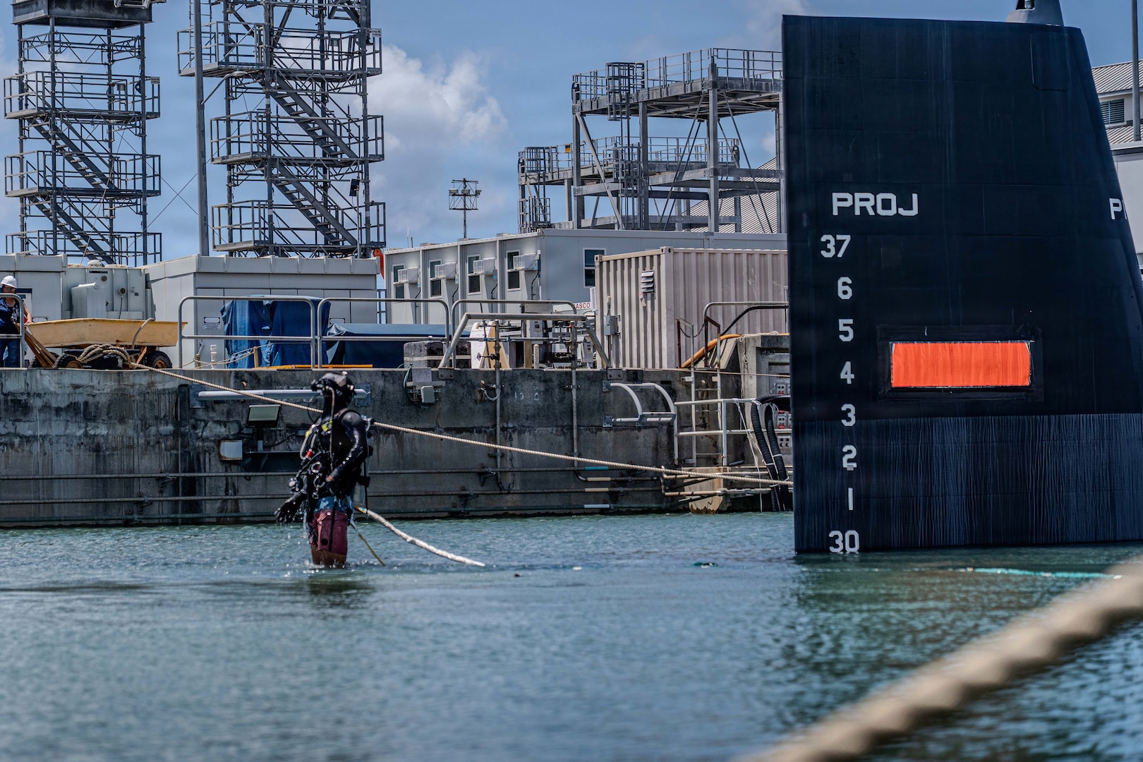A diver from Pearl Harbor Naval Shipyard and Intermediate Maintenance Facility awaits a crane during the undocking of Virginia-class fast-attack submarine USS Illinois (SSN 786) from Dry Dock 2 on June 24, 2026. Commissioned Oct. 29, 2016, Illinois is the 13th Virginia-class submarine. It is the second U.S. Navy ship to be named for the state of Illinois. Illinois is assigned to Submarine Squadron 1 and is capable of supporting various missions, including anti-submarine warfare; anti-surface ship warfare; strike warfare; special operations forces support; and intelligence, surveillance, and reconnaissance. PHNSY & IMF’s mission is to keep the Navy’s fleet “Fit to Fight" by repairing, maintaining, and modernizing the Navy's fast-attack submarines and surface ships. Strategically located in the heart of the Pacific, it is the most comprehensive fleet repair and maintenance facility between the U.S. West Coast and the Far East. (U.S. Navy photo by Kenny Jones)