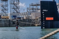 A diver from Pearl Harbor Naval Shipyard and Intermediate Maintenance Facility awaits a crane during the undocking of Virginia-class fast-attack submarine USS Illinois (SSN 786) from Dry Dock 2 on June 24, 2026. Commissioned Oct. 29, 2016, Illinois is the 13th Virginia-class submarine. It is the second U.S. Navy ship to be named for the state of Illinois. Illinois is assigned to Submarine Squadron 1 and is capable of supporting various missions, including anti-submarine warfare; anti-surface ship warfare; strike warfare; special operations forces support; and intelligence, surveillance, and reconnaissance. PHNSY & IMF’s mission is to keep the Navy’s fleet “Fit to Fight" by repairing, maintaining, and modernizing the Navy's fast-attack submarines and surface ships. Strategically located in the heart of the Pacific, it is the most comprehensive fleet repair and maintenance facility between the U.S. West Coast and the Far East. (U.S. Navy photo by Kenny Jones)