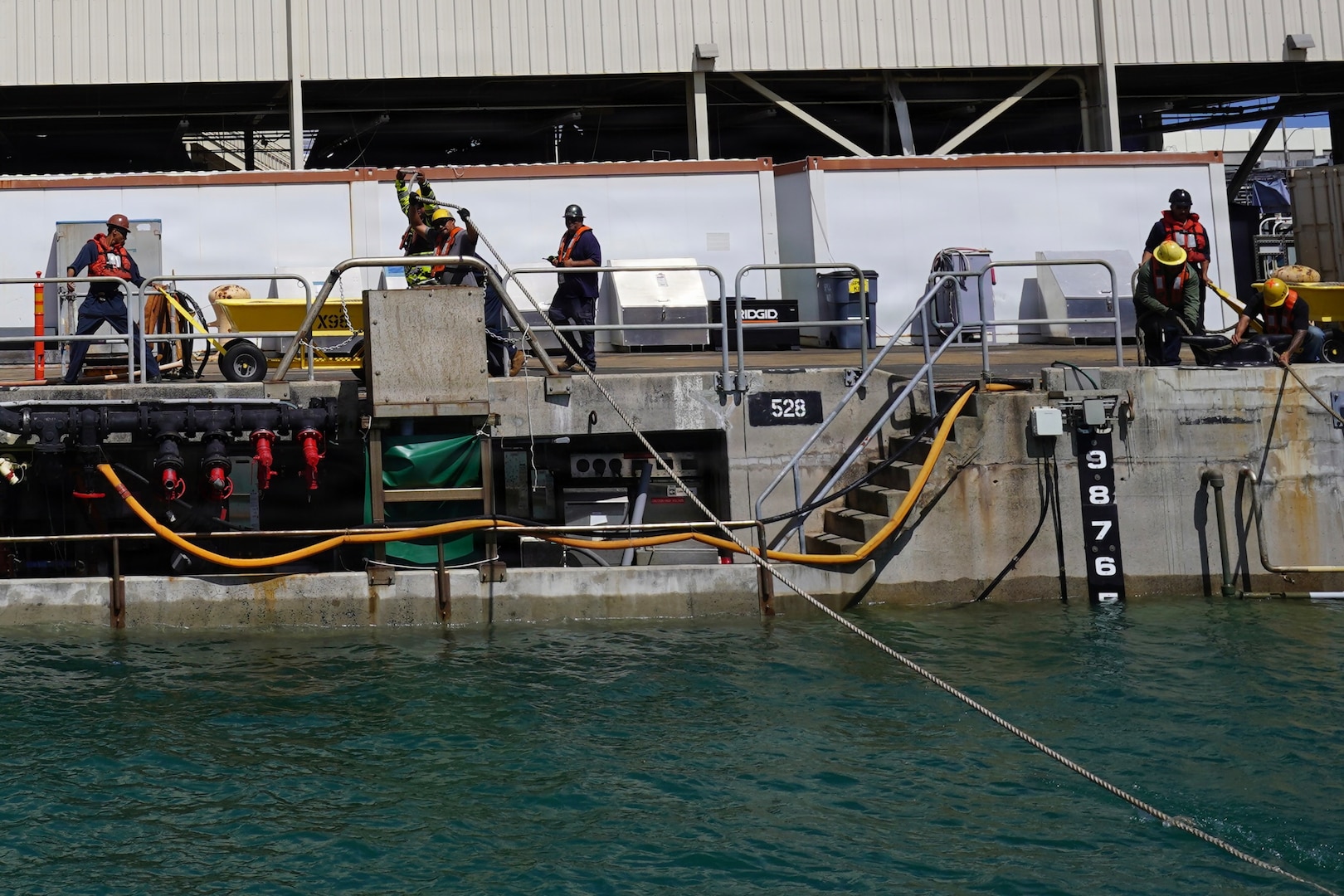 Riggers with Pearl Harbor Naval Shipyard and Intermediate Maintenance Facility (PHNSY & IMF) handle control lines during the undocking of USS Illinois (SSN 786) at Joint Base Pearl Harbor-Hickam, June 24, 2026. The Virginia-class fast-attack submarine left Dry Dock 2 at PHNSY & IMF, completing an important milestone in the submarine’s scheduled lifecycle maintenance period. Commissioned Oct. 29, 2016, Illinois is the 13th Virginia-class submarine. It is the second U.S. Navy ship to be named for the state of Illinois. Illinois is assigned to Submarine Squadron 1 and is capable of supporting various missions, including anti-submarine warfare; anti-surface ship warfare; strike warfare; special operations forces support; and intelligence, surveillance, and reconnaissance. PHNSY & IMF’s mission is to keep the Navy’s fleet “Fit to Fight" by repairing, maintaining, and modernizing the Navy's fast-attack submarines and surface ships. Strategically located in the heart of the Pacific, it is the most comprehensive fleet repair and maintenance facility between the U.S. West Coast and the Far East. (U.S. Navy photo by Claudia LaMantia)
