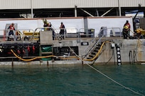 Riggers with Pearl Harbor Naval Shipyard and Intermediate Maintenance Facility (PHNSY & IMF) handle control lines during the undocking of USS Illinois (SSN 786) at Joint Base Pearl Harbor-Hickam, June 24, 2026. The Virginia-class fast-attack submarine left Dry Dock 2 at PHNSY & IMF, completing an important milestone in the submarine’s scheduled lifecycle maintenance period. Commissioned Oct. 29, 2016, Illinois is the 13th Virginia-class submarine. It is the second U.S. Navy ship to be named for the state of Illinois. Illinois is assigned to Submarine Squadron 1 and is capable of supporting various missions, including anti-submarine warfare; anti-surface ship warfare; strike warfare; special operations forces support; and intelligence, surveillance, and reconnaissance. PHNSY & IMF’s mission is to keep the Navy’s fleet “Fit to Fight" by repairing, maintaining, and modernizing the Navy's fast-attack submarines and surface ships. Strategically located in the heart of the Pacific, it is the most comprehensive fleet repair and maintenance facility between the U.S. West Coast and the Far East. (U.S. Navy photo by Claudia LaMantia)