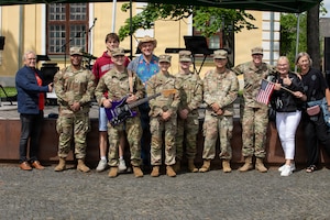 U.S. Soldiers assigned to the 1st Infantry Division Band, pose for a photo with Estonian locals after their U.S. Independence Day concert during the South-Estonia Rally in Võru, Estonia, July 4, 2026. The performance honored the United States' 250th anniversary of independence and celebrated the enduring partnership between the United States and Estonia while connecting audiences through music. V Corps is the U.S. Army's only forward-deployed corps, serving as the senior tactical headquarters for Army forces in Eastern Europe to deter conflict and provide combat-ready forces alongside our NATO Allies. V Corps is operationalizing and expanding the Eastern Flank Deterrence Initiative with Allies, rapidly integrating emerging technologies into training and tactical plans. (U.S. Army photo by Staff Sgt. Olivia Lauer, 196th Mobile Public Affairs Detachment)
