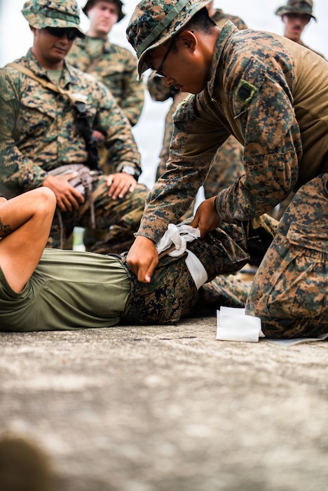 260624-M-NV743-1432 U.S. Navy Petty Officer 3rd Class Kyan Ysh Raguro, a hospital corpsman assigned to Damage Control Resuscitation Team, 3rd Medical Battalion, applies a tourniquet to a simulated casualty while instructing Marines and Sailors assigned to 3rd Littoral Combat Team, 3rd Marine Littoral Regiment, 3rd Marine Division, and Philippine marines assigned to 4th Marine Brigade, on Tactical Combat Casualty Care during KAMANDAG 10 at Calayan, Philippines, June 24, 2026. KAMANDAG 10 is a multi-domain, joint, and combined exercise between the Armed Forces of the Philippines and United States military focused on enhancing maritime security, interoperability, contested logistics, and combined readiness throughout the Philippine archipelago. Raguro is from New York. (U.S. Marine Corps photo by 2nd Lt. John Kim)
