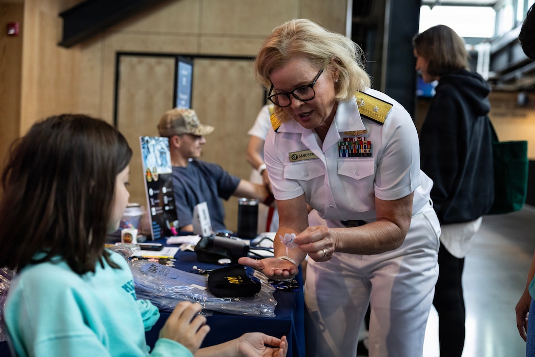 260621-N-VM650-1119 U.S. Navy Rear Adm. Kimberly Sandberg, reserve deputy director, Naval Medical Forces Atlantic, teaches members of the public about how to stop a bleeding wound inside of the Kiewit Luminarium in Omaha, Neb. during Omaha Navy Week, June 21.  Omaha Navy Week is the seventh of 12 Navy Weeks taking place in 2026 as part of the Navy Office of Community Outreach’s “Road Trip to 250,” a nationwide effort supporting America's 250th birthday, Freedom 250. Navy Weeks bring a variety of assets, equipment, and personnel to a single city for a weeklong series of engagements designed to connect communities across America with their Navy, highlighting shared history and the enduring commitment to defending freedom and supporting the nation’s independence. (U.S. Navy photo by Mass Communication Specialist 1st Class Charles J. Scudella III)