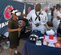 260703-N-N1526-1004 NEW YORK (July 3, 2026) Hospital Corpsman 1st Class Onojakpor Gabriel Ogboru, assigned to Navy Medicine Readiness and Training Command (NMRTC) Fort Belvoir, shows a visitor how to operate a virtual reality simulator for Navy Medicine STEM careers at the U.S. Navy STEM booth at the Intrepid Museum during the International Naval Review 250 (INR 250) in New York, July 3, 2026. For 250 years, the U.S. Navy and Marine Corps stood watch – constant, unabated in mission, faithfully preventing crisis and resolute in defending America’s independence. INR 250 honors the Navy, Marine Corps, and Coast Guard’s enduring role on, under, and above the seas.  (U.S. Navy Capt. Bill Urban)