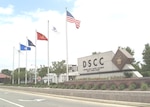 Outside photo of DSCC sign to the right and flags to the left