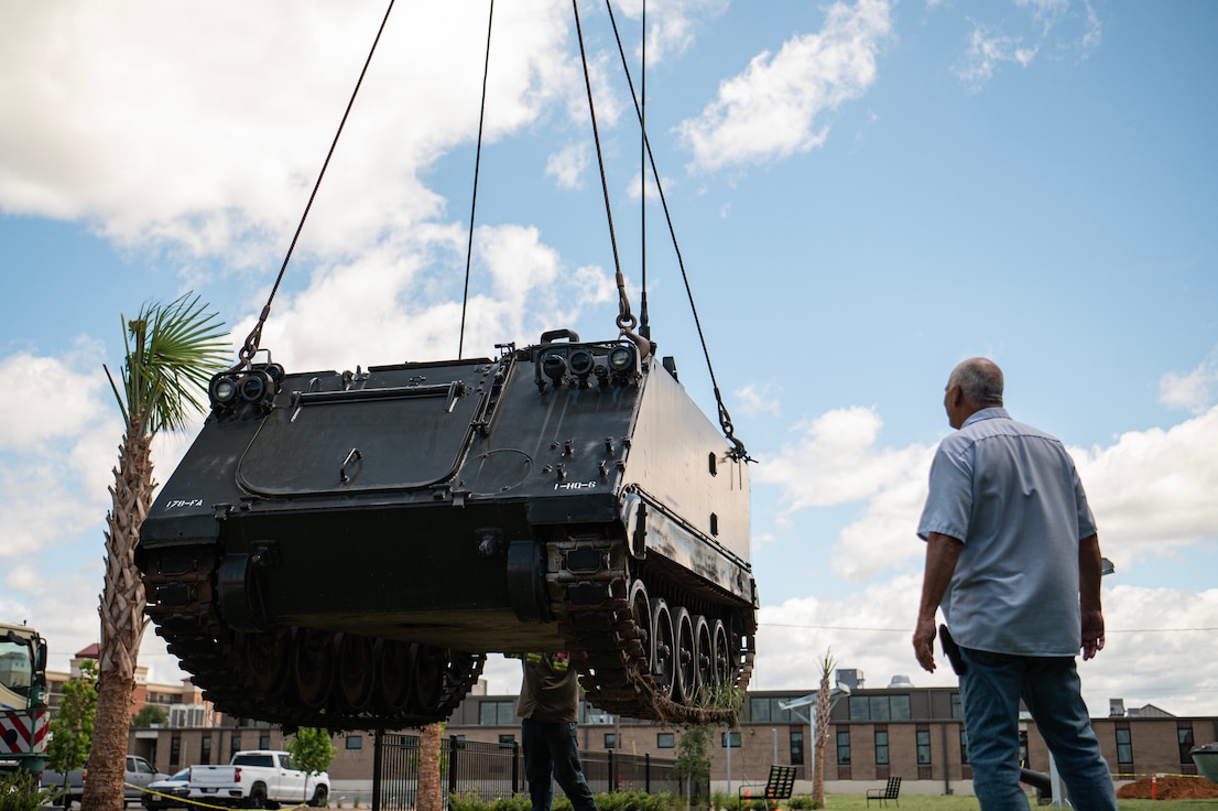 crane placing military vehicle in front of south carolina military museum