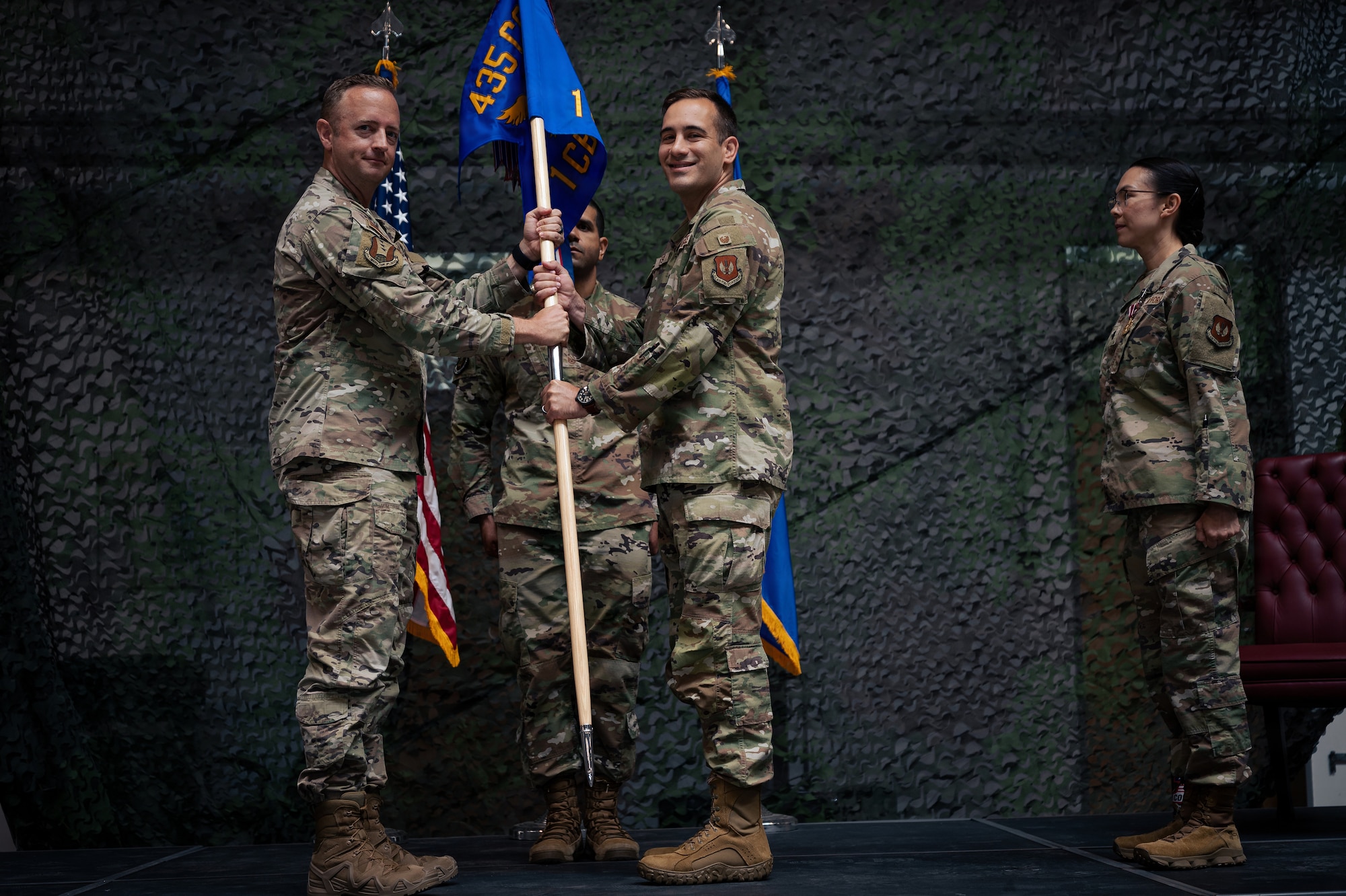 two Airman hold a guidon