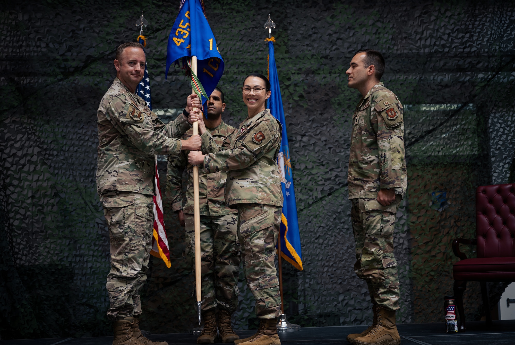 two Airman hold a flag pole