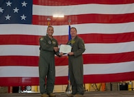 U.S. Air Force Col. John Burrell, 5th Operations Group (OG) outgoing commander, right, receives the legion of Merit certificate from U.S. Air Force Col. Jesse Lamarand, 5th Bomb Wing commander, left, during a change of command ceremony at Minot Air Force Base, North Dakota, July 7, 2026. As the 5th OG commander, Burrell was responsible for leading the operational flying mission of the 5th Bomb Wing.