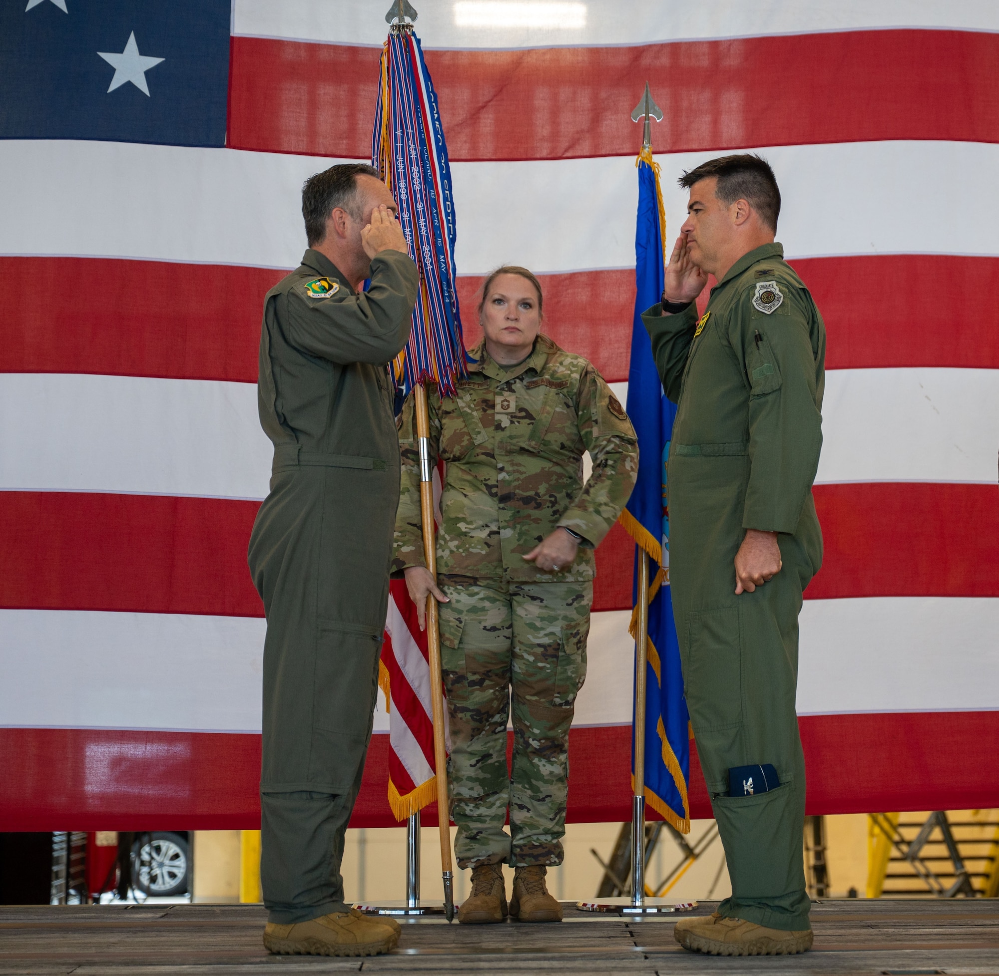 U.S. Air Force Col. Jesse Lamarand, 5th Bomb Wing commander, left, relinquishes the guidon to U.S. Air Force Col. Bryson Ayers 5th Operations Group (OG) incoming commander, right, during a change of command ceremony at Minot Air Force Base, North Dakota, July 7, 2026. As the incoming commander, Ayers will be directly responsible for the people who fly the B-52's at Minot, making sure the aircraft, crews and operational systems are prepared, certified and ready to execute the nation's strategic bomber mission at any time.