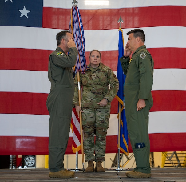 U.S. Air Force Col. Jesse Lamarand, 5th Bomb Wing commander, left, relinquishes the guidon to U.S. Air Force Col. Bryson Ayers 5th Operations Group (OG) incoming commander, right, during a change of command ceremony at Minot Air Force Base, North Dakota, July 7, 2026. As the incoming commander, Ayers will be directly responsible for the people who fly the B-52's at Minot, making sure the aircraft, crews and operational systems are prepared, certified and ready to execute the nation's strategic bomber mission at any time.