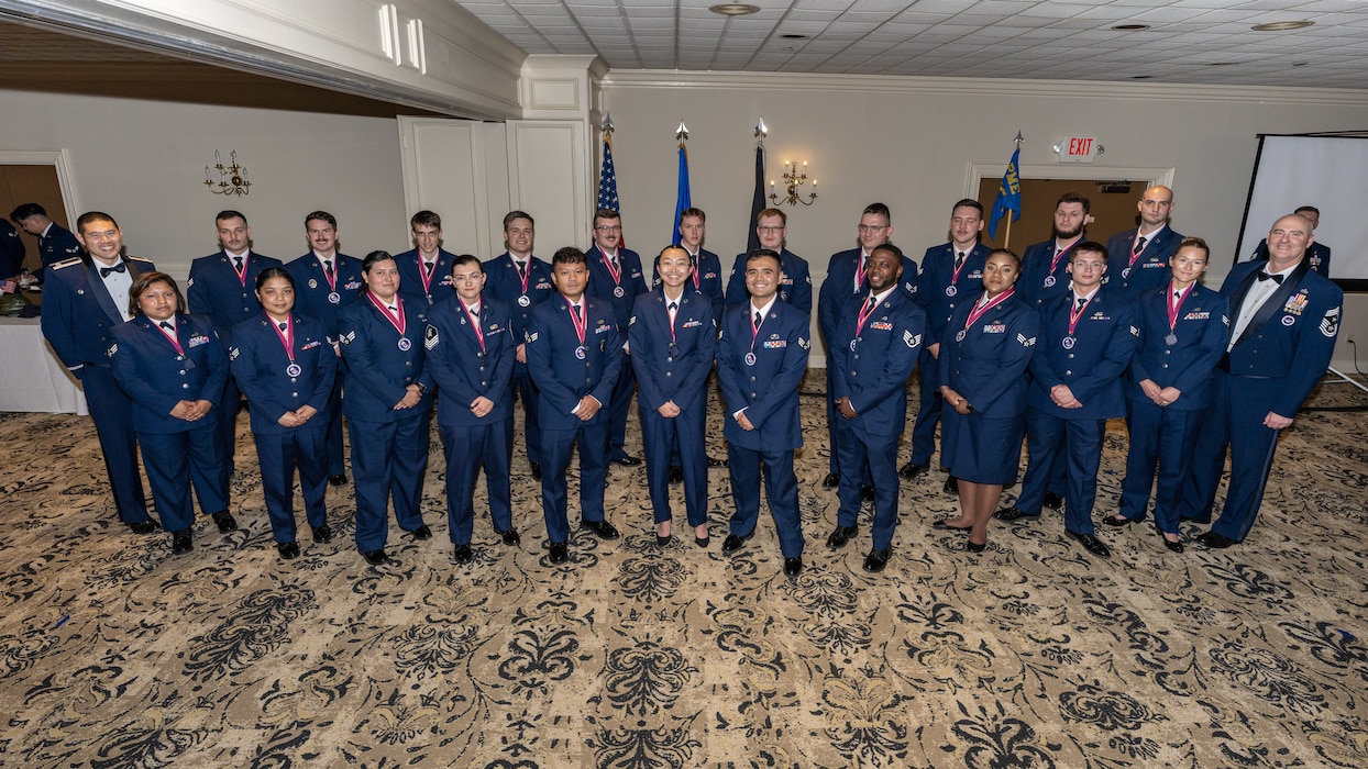 A large group photo of men and women wearing formal blue military uniforms