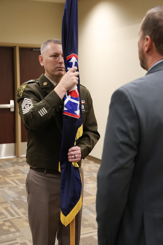 Command Sergeant Major Michael A. Ringman receives the colors from Director L. Scott Moreland
