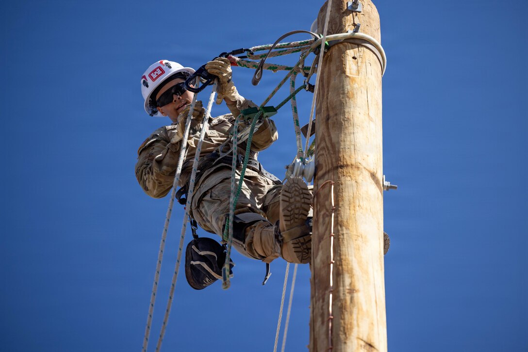 U.S. Army Reserve Pfc. Thomas Deguire, a Prime Power Production Specialist (12Q) assigned to Delta Company, 249th Engineer Battalion, installs single-phase power lines on the Navajo Nation Reservation in Leupp, Arizona, May 7, 2026. Deguire and other Soldiers installed more than two miles of conductor as part of an ongoing mission to expand electrical infrastructure across tribal lands by installing approximately 150 main distribution power poles and lines over a 10-mile stretch, helping connect homes within the Navajo Nation to reliable electricity. (U.S. Army Reserve photo by Staff Sgt. David Cook)