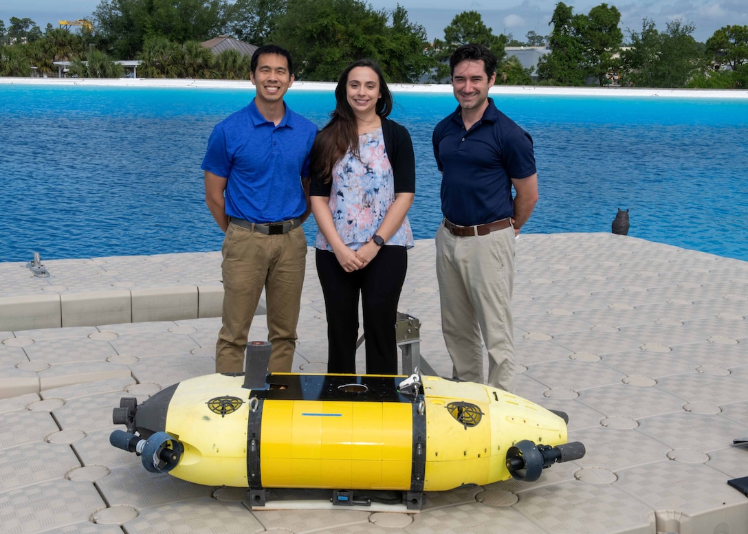 Members of the Mission Effectiveness & Assessment with Subsea Recognition (MEASUR) team (from left) Dr. Spencer Chang, Dr. Adriana McKinney and Dr. Tony Diaz, are shown with the Science & Technology Engineering Innovation Vehicle, or STEIV, at NSWC Panama City Division’s test pond. By equipping unmanned underwater vehicles with advanced sensors and artificial intelligence, MEASUR automatically and accurately evaluates physical damage to underwater threats. (Not pictured) Dr. Kwang Lee, Peter Romaine and Dr. Minh Chau. (U.S. Navy photo by Ronnie Newsome)