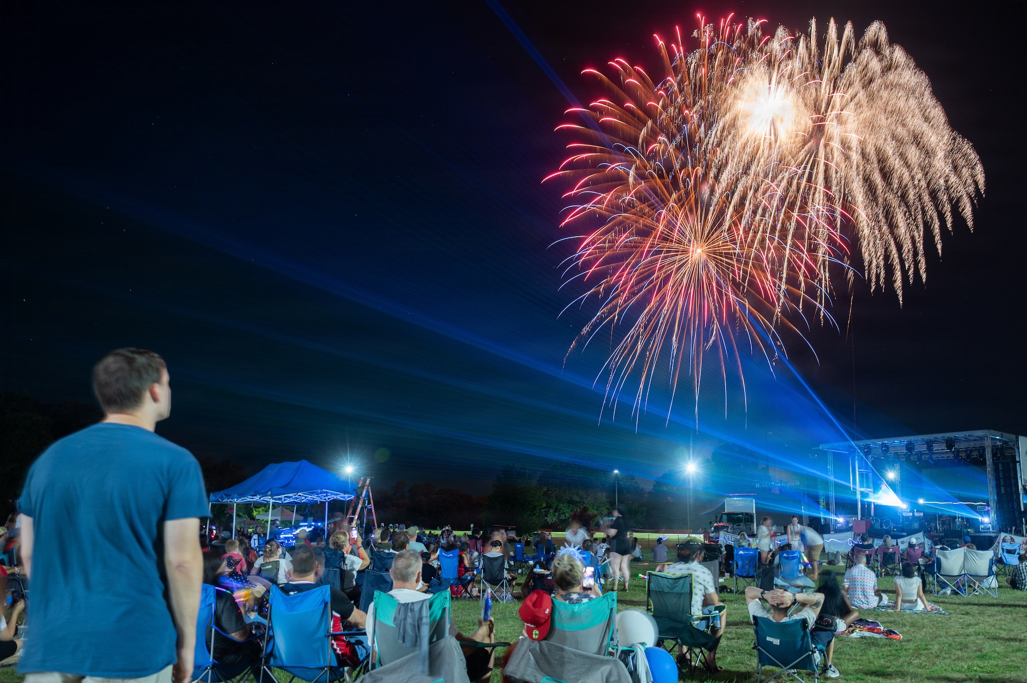 a crowd watches a fireworks show