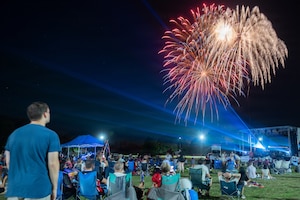 a crowd watches a fireworks show