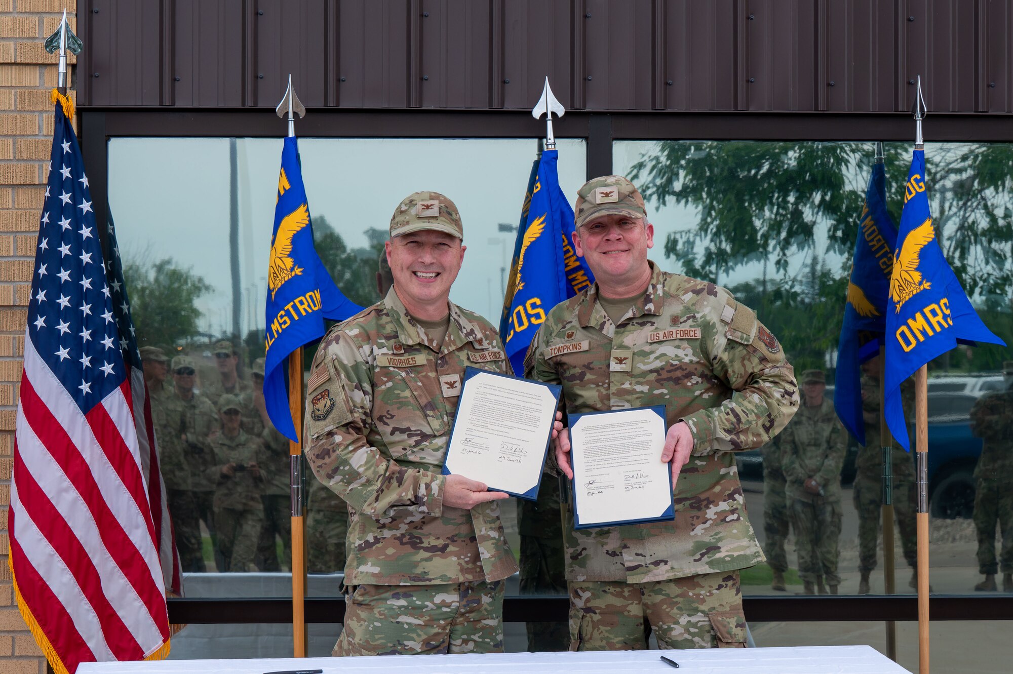 U.S. Air Force Col. Daniel Voorhies, 341st Missile Wing commander, left, and Col. Jason Tompkins, Malmstrom Medical Group commander, pose with signed memorandums during the Air Force Medical Command’s fourth inter-command transfer, at Malmstrom Air Force Base, Montana, June 26, 2026.