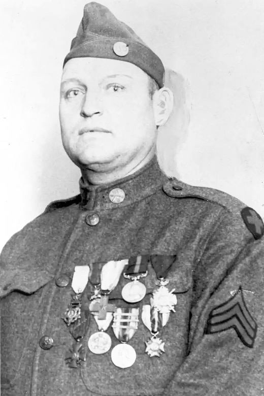 A man wearing a military uniform has medals around his left pocket.