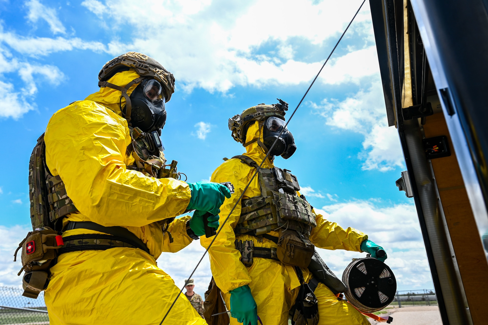 Image of two airmen in yellow hazmat suits