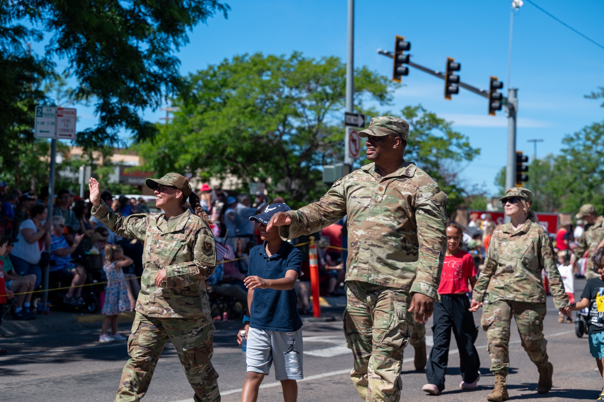 Uniformed personnel walk alongside their children and fellow Airmen.
