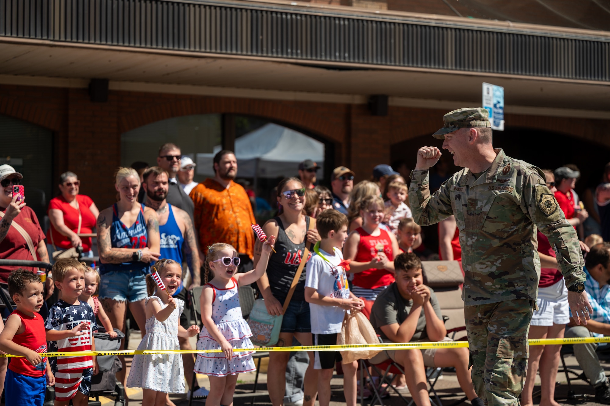 A uniformed man greets a crowd of people.