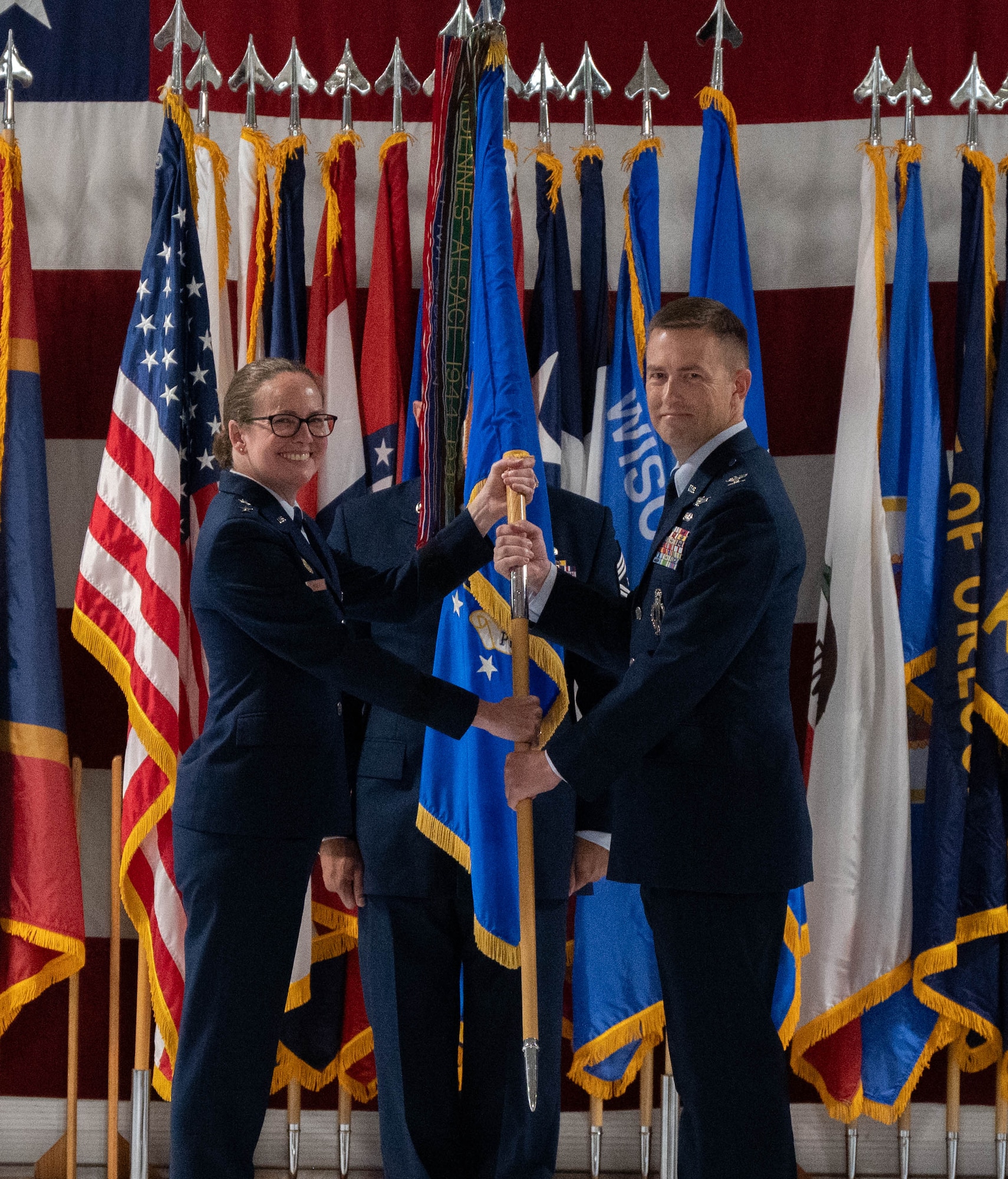 U.S. Air Force Col. George Chapman, incoming 91st Missile Wing (91st MW) commander, right, passes the 91st MW guidon to U.S. Air Force Maj. Gen. Stacy Jo Huser, 20th Air Force commander, left, during a change of command at Minot Air Force Base, North Dakota, July 8, 2026. The 91st MW is one of the Air Force's three operational missile units. The 91st MW maintains a fleet of Minuteman III intercontinental ballistic missiles and its mission is to defend the nation with a combat-ready nuclear force. (U.S. Air Force photo by Airman Benjamin Selchow)