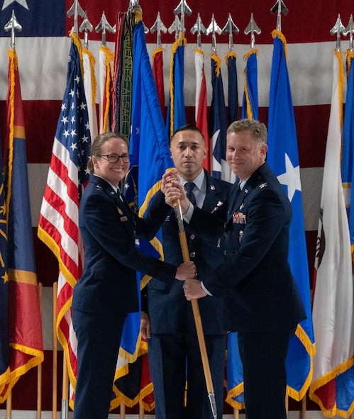 U.S. Air Force Col. James Schlabach, outgoing 91st Missile Wing (91st MW) commander, right, receives the 91st MW guidon from U.S. Air Force Maj. Gen. Stacy Jo Huser, 20th Air Force commander, left, assuming command of the 91st MW during a change of command ceremony at Minot Air Force Base, North Dakota, July 8, 2026. Schlabach reflected on the accomplishments of the 91st MW, praising the Airmen and staff that worked under his command for their dedication and work towards the mission of global deterrence. (U.S. Air Force photo by Airman Benjamin Selchow)