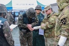 A U.S. Army soldier, acting as a simulated casualty with a sprained wrist, is evaluated by Republic of Korea Army nursing officers at Deokjeong Station, South Korea, during the Dragon Lift evacuation exercise.
