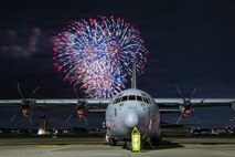 Fireworks burst behind a C-130J Super Hercules assigned to the 36th Airlift Squadron during Celebrate America at Yokota Air Base, Japan, July 4, 2026.