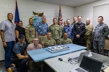 U.S. Navy Rear Adm. Josh Lasky, Commander, Joint Task Force-Micronesia, Dr. John Wood, U.S. Pacific Command’s J7 Training and Exercises Deputy Director, military leaders, and support personnel celebrate the opening of the Pacific Multi-Domain Training and Experimentation Capability Forward - Guam facility following a ribbon-cutting ceremony at Building 4175 on U.S. Naval Base Guam, June 22, 2026.