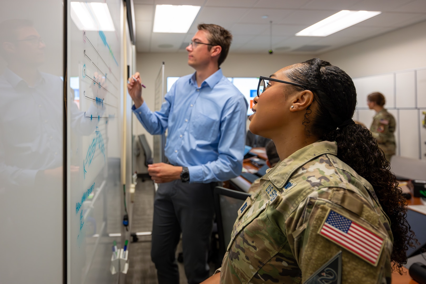 Military members and civilians work at training event.