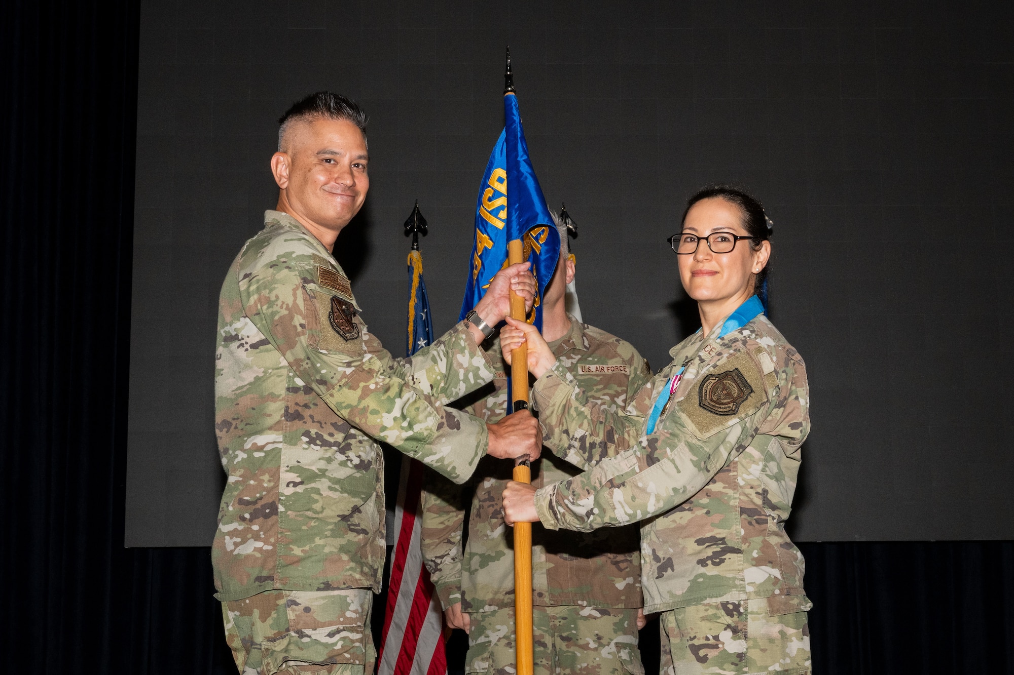 An outgoing commander ceremoniously passes a guidon.