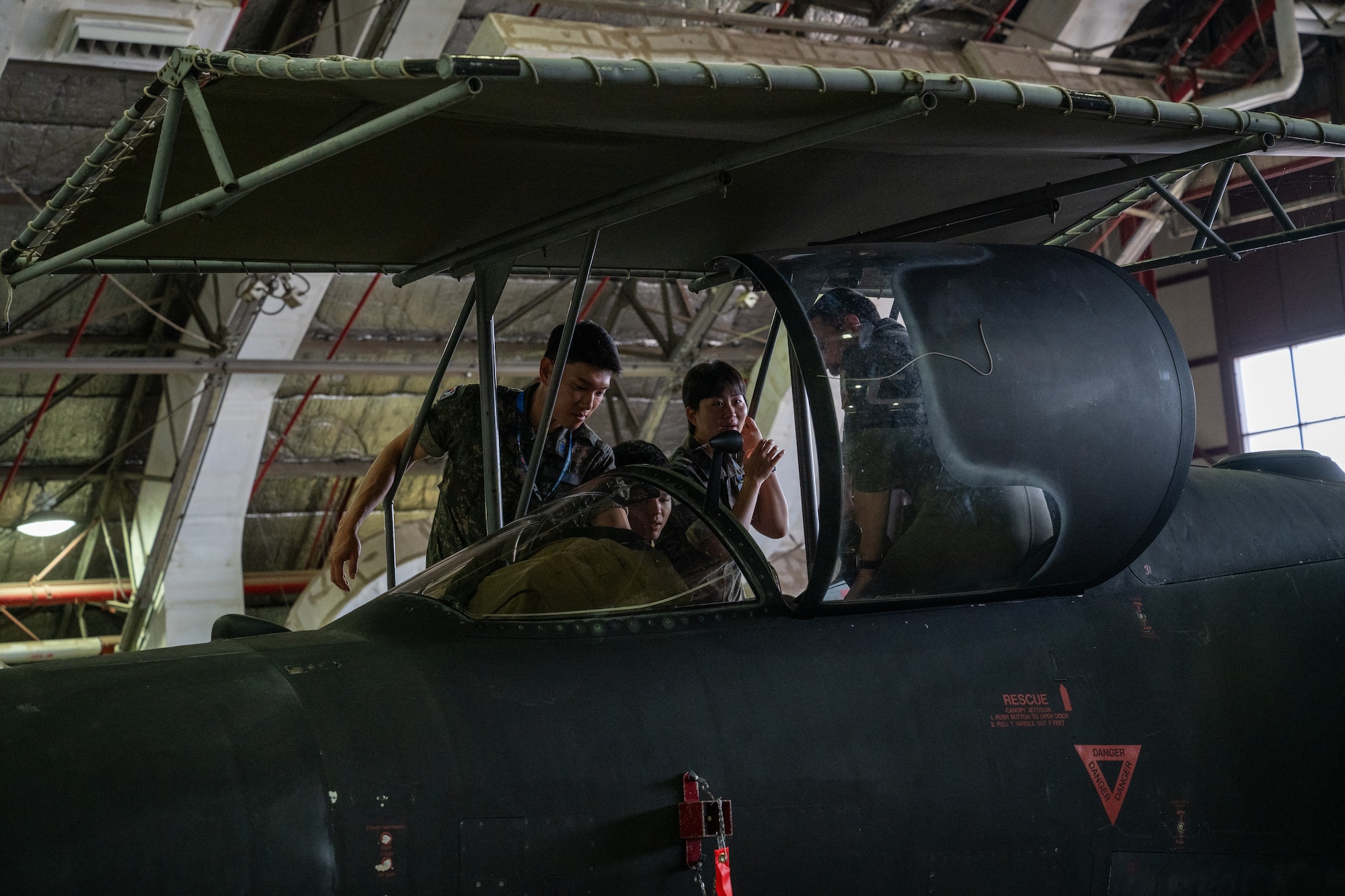 A pilot shows an aircraft's cockpit to ROKAF Airmen.