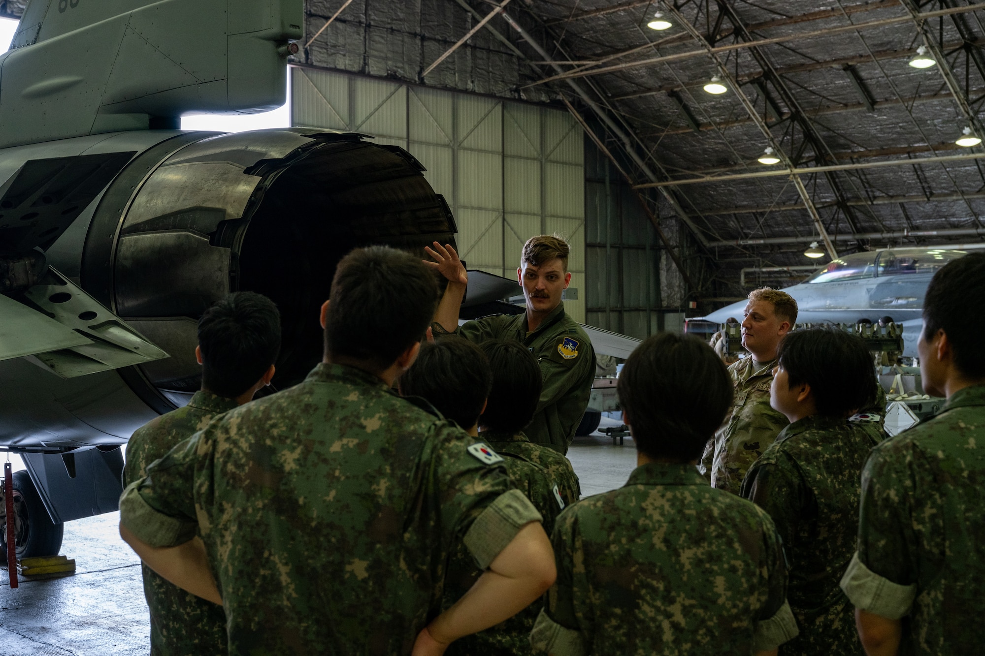 A fighter pilot briefs ROKAF Airmen on an aircraft's capabilities.