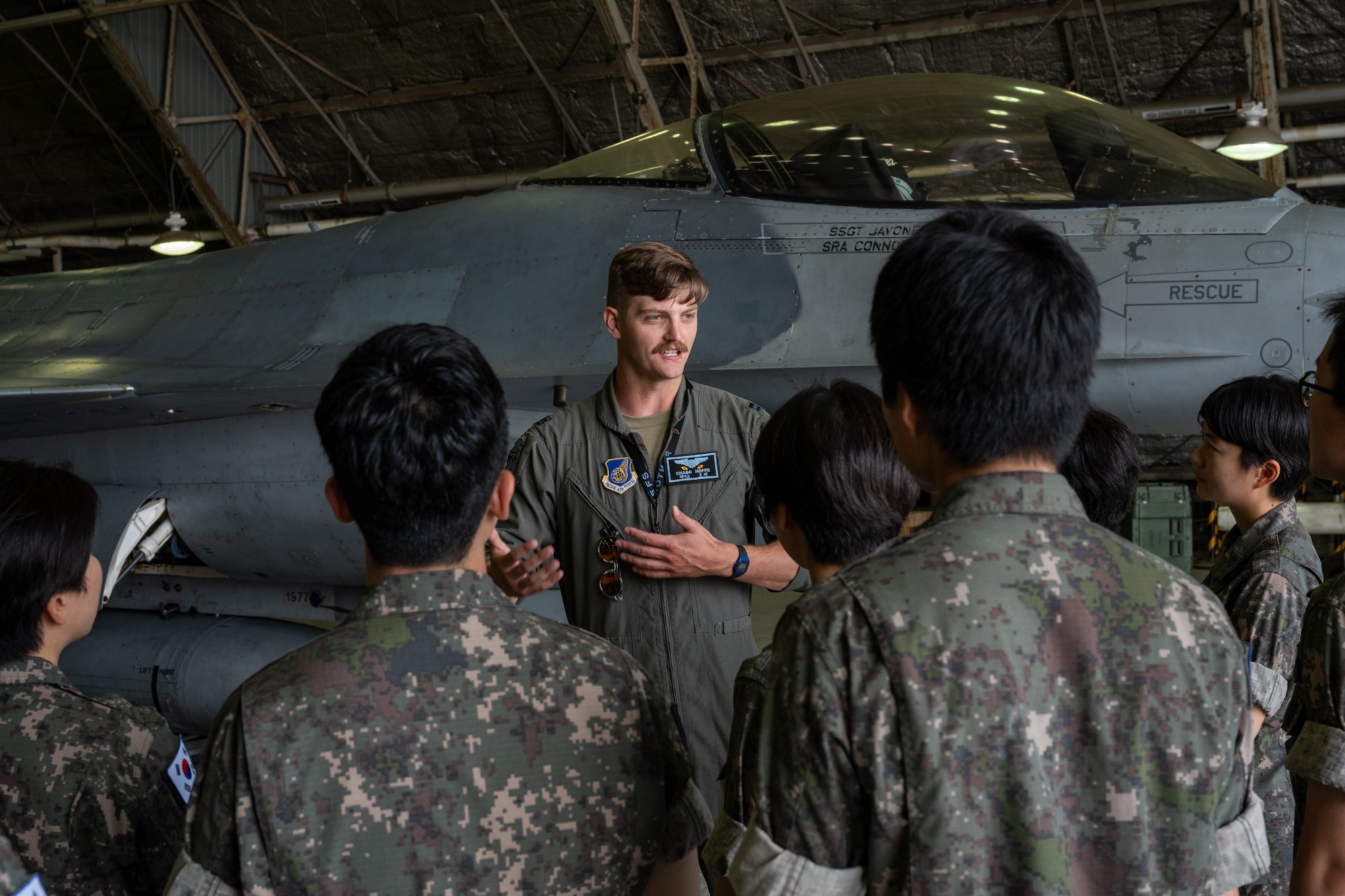 A fighter pilot briefs ROKAF Airmen on the aircraft's capabilities.