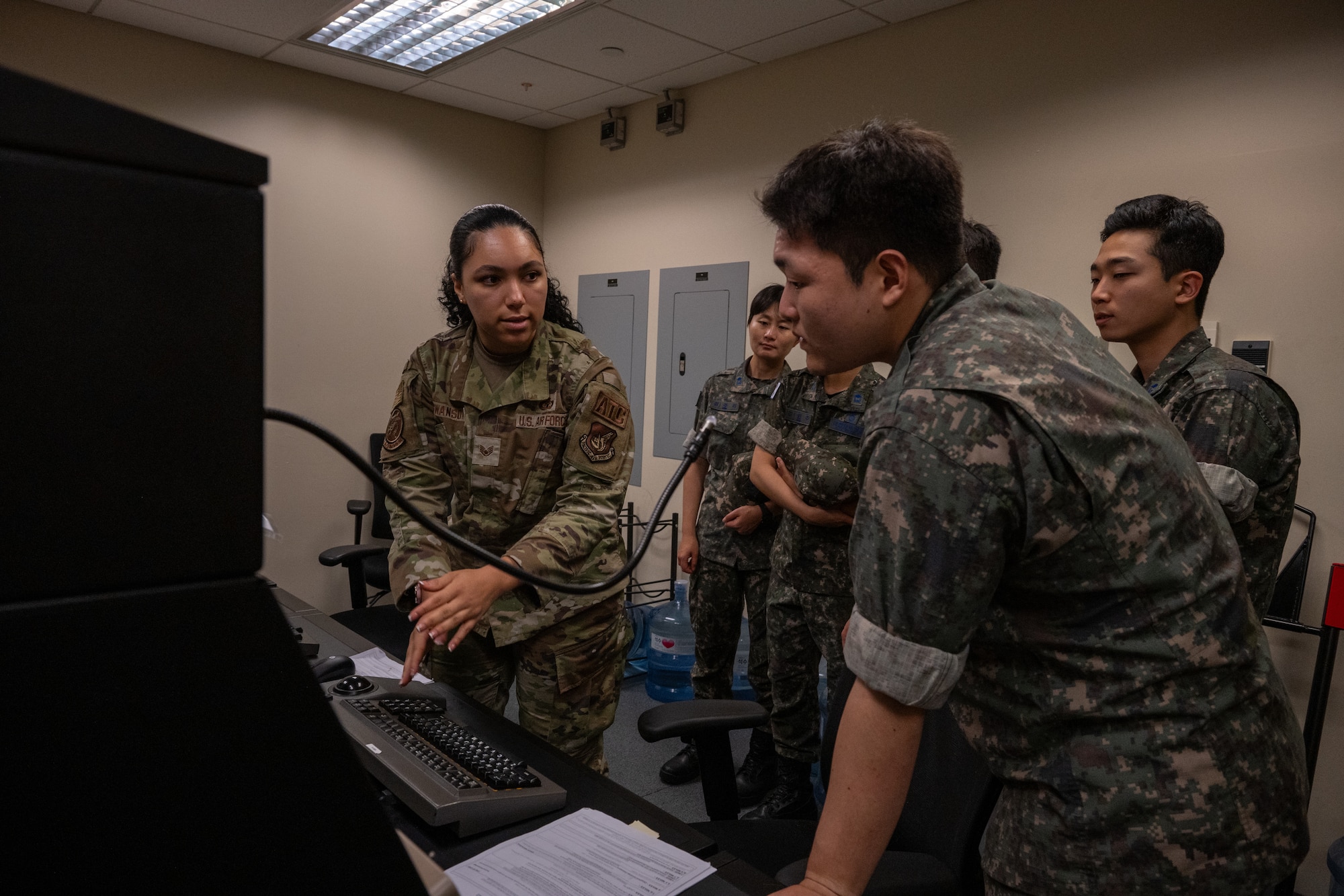 An Airman shows air traffic control training equipment to ROKAF translators.