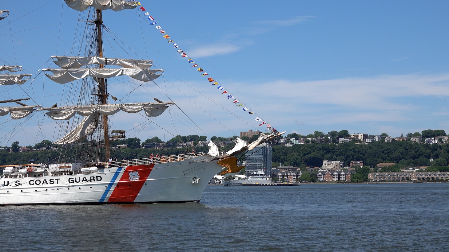 U.S. Coast Guard Cutter Eagle (WIX 327) displays signal flags as it transits the Hudson River near the Royal Moroccan Navy frigate RMNS Mohammed VI (701) during International Naval Review 250. The multinational maritime event commemorates the 250th anniversary of the United States and highlights cooperation among participating maritime forces. (U.S. Navy photo by Lt. Cmdr. Darius A. Radzius)