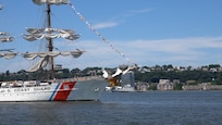 U.S. Coast Guard Cutter Eagle (WIX 327) displays signal flags as it transits the Hudson River near the Royal Moroccan Navy frigate RMNS Mohammed VI (701) during International Naval Review 250. The multinational maritime event commemorates the 250th anniversary of the United States and highlights cooperation among participating maritime forces. (U.S. Navy photo by Lt. Cmdr. Darius A. Radzius)