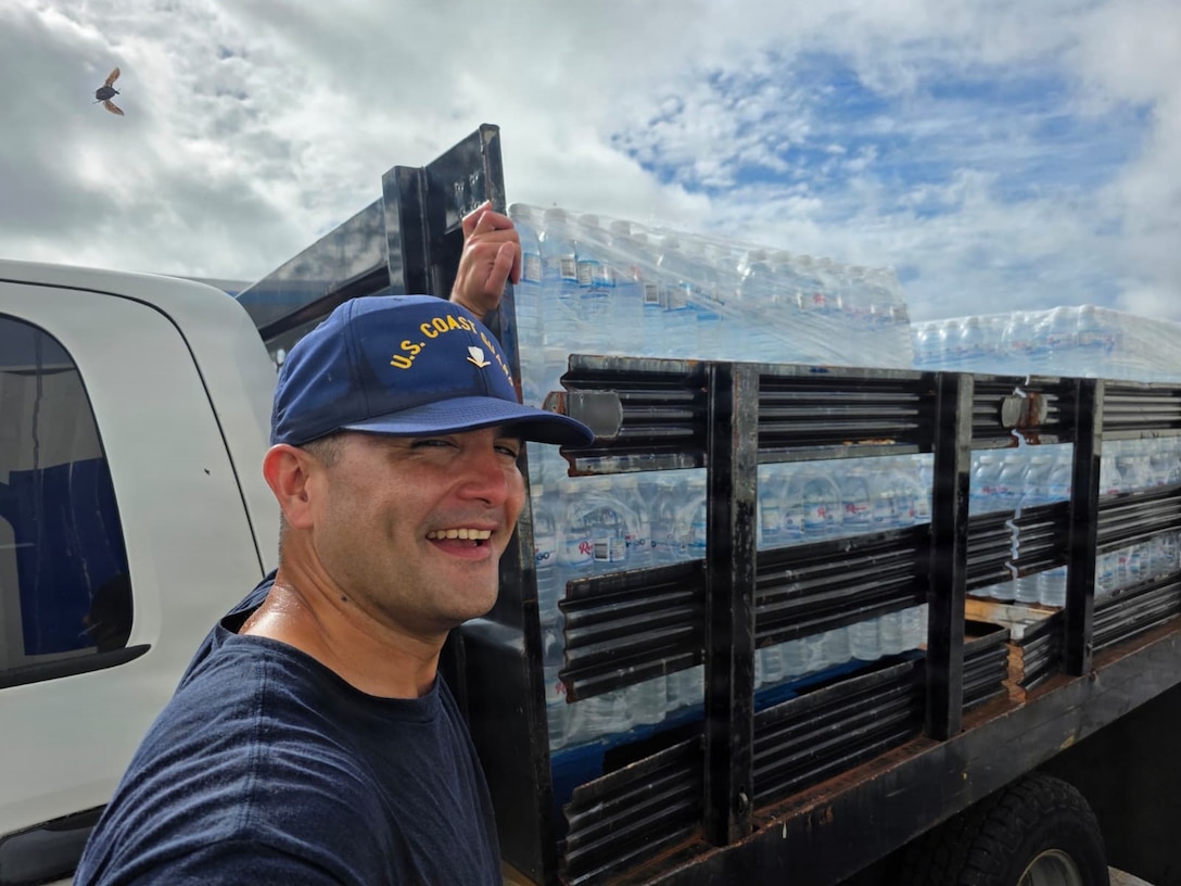 Personnel from U.S. Coast Guard Base Guam and Forces Micronesia/Sector Guam coordinate with the community in Guam to transport pallets of water to a U.S. Coast Guard HC-130J Hercules airplane from Air Station Barbers Point, in concert with planned damage assessments of Rota in the Northern Mariana Islands, on July 9, 2026. U.S. Coast Guard crews continue to assess and rectify discrepancies to aids to navigation, waterways, and channel conditions across the Marianas following Super Typhoon Bavi. (U.S. Coast Guard photo by Senior Chief Petty Officer Kevin Reilly)