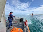 A U.S. Coast Guard Station Apra Harbor 45-foot Response Boat-Medium crew tows Buoy 2 from the entrance of Outer Apra Harbor, Guam, on July 9, 2026. U.S. Coast Guard Forces Micronesia/Sector Guam, Station Apra Harbor, and U.S. Navy Explosive Ordnance Disposal Mobile Unit Five personnel worked together to remove Buoy 2, which moved off station during the storm, into the channel, where vessels expect safe water. (U.S. Coast Guard photo by Chief Petty Officer Neil Rice)
