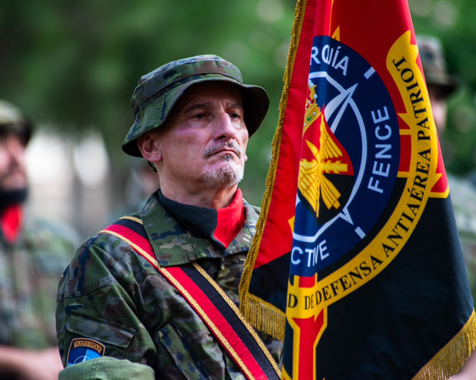 A Spanish army member assigned to the Spanish Patriot Unit stands with a guidon.